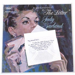 May include: A vintage vinyl record album cover featuring a woman holding a letter. The album is titled "The Letter" by Judy Garland. The letter reads, "My dearest dear, I write this letter because I have no other choice. Life without you is tolerable. I tried to fill my world kinds of distractions - stupid hobbies - but my mind keeps running."