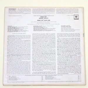 May include: A vintage vinyl record album cover featuring Doris Day and Robert Goulet. The album is titled "Annie Get Your Gun" and features a photo of Doris Day and Robert Goulet in a theatrical pose. The back of the album features a detailed description of the album and the artists.
