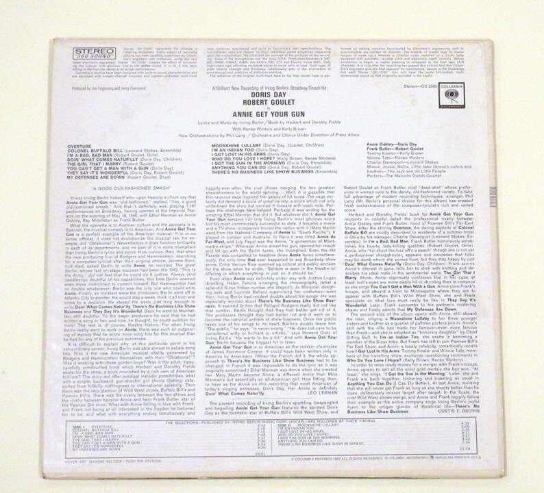 May include: A vintage vinyl record album cover featuring Doris Day and Robert Goulet. The album is titled "Annie Get Your Gun" and features a photo of Doris Day and Robert Goulet in a theatrical pose. The back of the album features a detailed description of the album and the artists.
