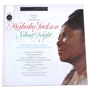 May include: A vintage vinyl record album cover featuring a portrait of Mahalia Jackson, a famous gospel singer, with the title "Silent Night" and a list of Christmas songs. The album cover is white with green and red accents.
