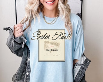 Puede incluir: Camiseta azul claro con un diseño de etiqueta de vino vintage con el texto "Parker Knoll 1993 Chardonnay Napa Valley".