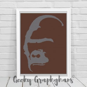 May include: A framed print featuring a gray gorilla silhouette on a brown background. The artwork is set against a white brick wall. The text "Geeky Graphghans" is at the bottom.