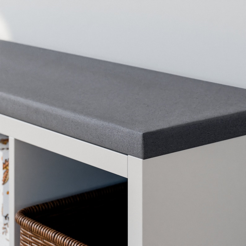 Peut inclure: Une &eacute;tag&egrave;re blanche avec un dessus gris. L'&eacute;tag&egrave;re a un panier tiss&eacute; sur l'&eacute;tag&egrave;re inf&eacute;rieure.