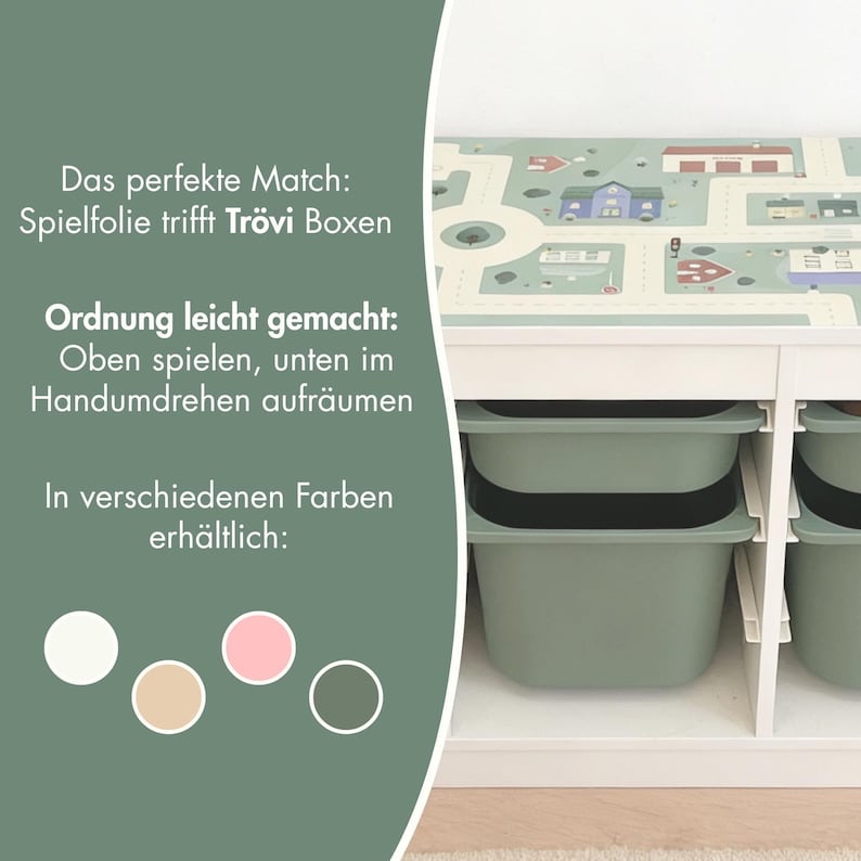 May include: A white storage unit with sage green bins and a top surface featuring a printed town map. Text on the left reads: Das perfekte Match: Spielfolie trifft Tr&ouml;vi Boxen, Ordnung leicht gemacht: Oben spielen, unten im Handumdrehen aufr&auml;umen, In verschiedenen Farben erh&auml;ltlich, with four color circles below.
