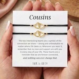 May include: A set of three ceramic mugs with a speckled, cream-colored glaze. Each mug features a different hand-painted design: a blue and green leaf, a yellow flower, and a red berry. The mugs have a simple, modern design.