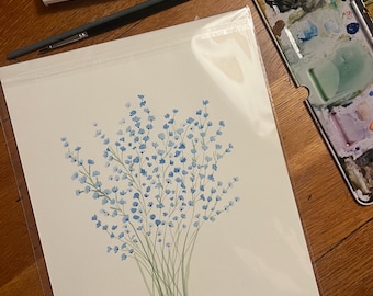 May include: Watercolor painting of a bouquet of blue flowers with green stems. The artwork is in a clear plastic sleeve. A watercolor palette, paintbrushes, and a watercolor paint set are also visible.
