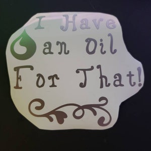 Può includere: Un adesivo bianco con un'icona di goccia d'olio verde e il testo "Ho un olio per questo!" in un carattere decorativo.