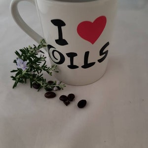 Pode incluir: Caneca de cerâmica branca com um design preto e vermelho que diz "Eu amo óleos".