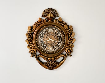 Rococo-wandklok uit de jaren 60 sierlijke gouden hars kunststof met sunburst-wijzerplaat