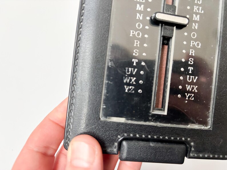 Puede incluir: Un libro de direcciones negro vintage con un selector de letras deslizante. El selector tiene letras de la A a la Z, con una cubierta de pl&aacute;stico transparente. El libro est&aacute; hecho de material negro similar al cuero y tiene forma rectangular.
