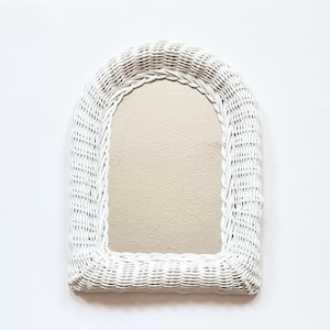 Peut inclure: Miroir en osier blanc en forme d'arche avec un miroir beige.