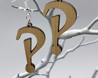 May include: A pair of wooden earrings shaped like question marks. The earrings are brown and have a natural wood grain. They are hanging from silver hooks.