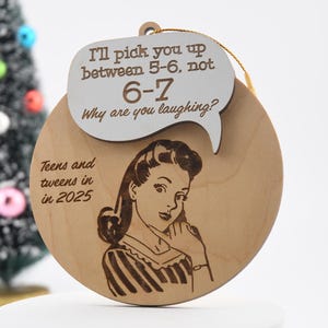 May include: Wooden Christmas ornament with a retro illustration of a woman on the phone. The ornament has the text "I'll pick you up between 5-6, not 6-7. Why are you laughing?" and "Teens and tweens in 2025."