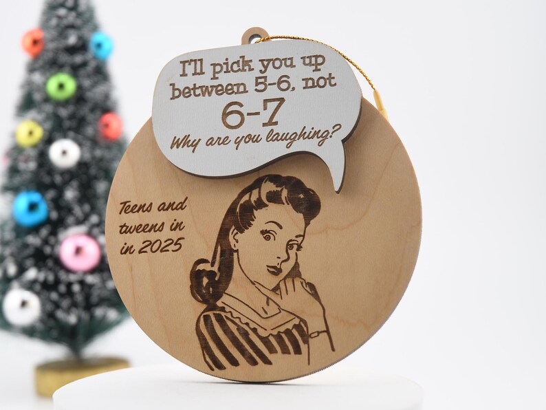 May include: Wooden Christmas ornament with a retro illustration of a woman on the phone. The ornament has the text "I'll pick you up between 5-6, not 6-7. Why are you laughing?" and "Teens and tweens in 2025."