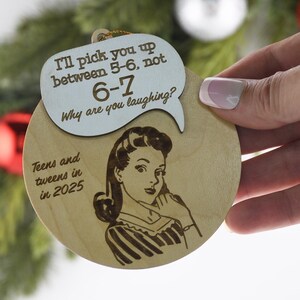 May include: Wooden Christmas ornament with a retro illustration of a woman and a speech bubble. The speech bubble says "I'll pick you up between 5-6, not 6-7. Why are you laughing?" and "Teens and tweens in 2025".