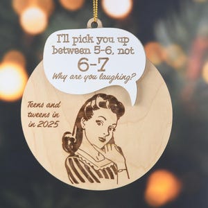 May include: Wooden Christmas ornament with a retro illustration of a woman and text in a speech bubble that reads "I'll pick you up between 5-6, not 6-7. Why are you laughing?" The ornament also says "Teens and tweens in in 2025."