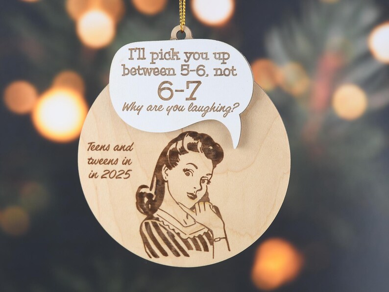 May include: Wooden Christmas ornament with a retro illustration of a woman and text in a speech bubble that reads "I'll pick you up between 5-6, not 6-7. Why are you laughing?" The ornament also says "Teens and tweens in in 2025."