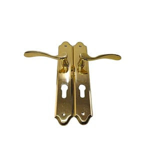 May include: A pair of gold door handles with a traditional design. Each handle has a keyhole and a curved lever.