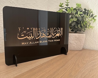 May include: Black acrylic plaque with gold Arabic calligraphy and the text "May Allah Bless This Home".