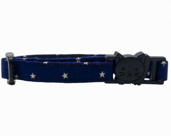 May include: A navy blue cat collar with white stars and a black cat-shaped buckle.