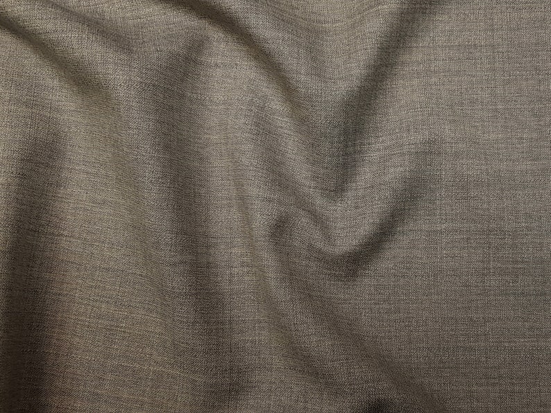 May include: Close-up of a brown fabric with a subtle woven texture. The fabric has a slightly rough feel and a slightly shiny appearance.