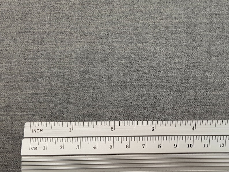 May include: A close-up of a gray, textured fabric with a ruler measuring 12 inches or 30.48 centimeters.
