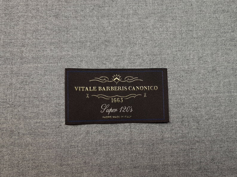 May include: A black fabric label with gold text that reads "VITALE BARBERIS CANONICO 1663 Super 120's FABRIC MADE IN ITALY"