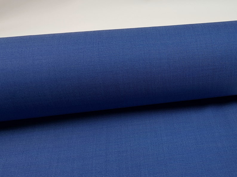May include: A roll of blue fabric. The fabric has a smooth, even texture.