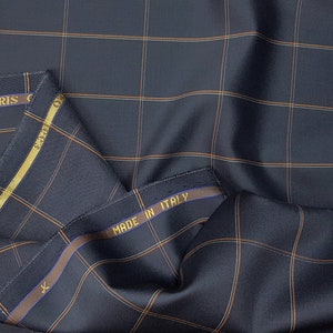 K&ouml;nnte beinhalten: Ein dunkelblauer Stoff mit einem braunen und wei&szlig;en Karomuster. Der Stoff hat ein Etikett mit der Aufschrift "Made in Italy".