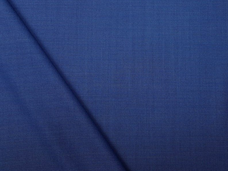 May include: A close-up of a dark blue fabric with a subtle textured pattern.