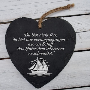 Könnte beinhalten: Eine schwarze herzförmige Schiefertafel mit einer weißen Segelbootgrafik und dem Text "Du bist nicht fort, du bist nur vorausgegangen - wie ein Schiff, das hinter dem Horizont verschwindet."