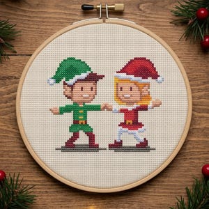 May include: A cross-stitch embroidery hoop featuring two pixelated elf figures. One elf wears a green outfit and hat, the other a red outfit and hat. The figures are holding hands. The hoop is set against a wooden background with Christmas decorations.