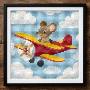 Puede incluir: Obra de arte de punto de cruz de un ratón marrón pilotando un biplano rojo y amarillo contra un cielo azul con nubes blancas. La pieza enmarcada es un diseño encantador y caprichoso, perfecto para la habitación de un niño o guardería.