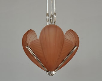 May include: A pink glass and chrome Art Deco style pendant light fixture. The fixture has a flower-shaped shade with a frosted glass finish.