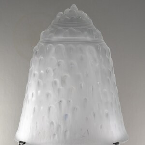 May include: A white frosted glass lampshade with a textured, ribbed design. The shade is bell-shaped and has a rounded top.
