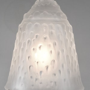 May include: A frosted glass lampshade with a textured, bubble-like design. The shade is white and has a silver metal rim.