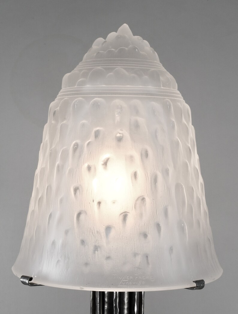 May include: A frosted glass lampshade with a textured, bubble-like design. The shade is white and has a silver metal rim.