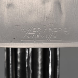 May include: Close-up of a white glass lampshade with the inscription "VER FRERES VREVILE" etched into the bottom.