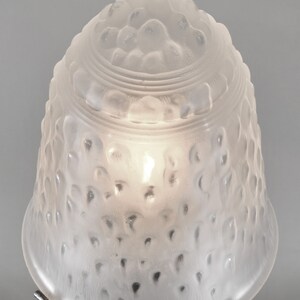 May include: A frosted glass lampshade with a textured, bubble-like design. The shade is white and has a round, bell-shaped form.