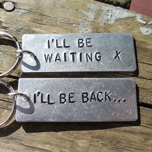 May include: Two silver keychains with the text "I'll be waiting x" and "I'll be back..." engraved on them.