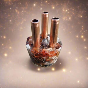 May include: A copper and crystal incense burner with three copper tubes. The burner is filled with various crystals and stones, including carnelian, clear quartz, and gold flakes.