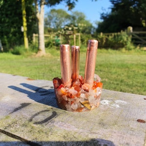 May include: A copper pipe holder with three pipes, set in a base of carnelian and clear quartz crystals.
