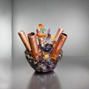 May include: A copper and crystal vase with a variety of colorful gemstones, including amethyst, citrine, and clear quartz. The vase has five copper tubes that can be used to hold flowers or other decorative items.