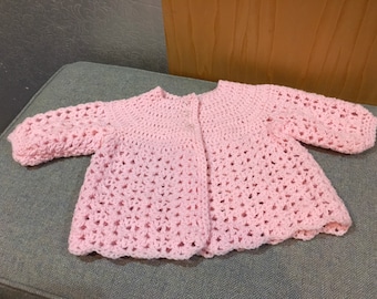 Pink hand crocheted baby cardigan. 3 to 6 months , 20” chest. Pretty and soft with clear flower buttons.