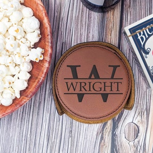 May include: Brown leather coaster with a monogrammed initial "W" and the name "WRIGHT" in black lettering.