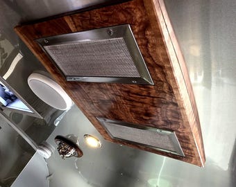 May include: A custom-built range hood with a rich, dark wood grain finish. The hood features two stainless steel mesh filters set within a rectangular frame. The StreamReturn™ and CraeFt logos are visible.