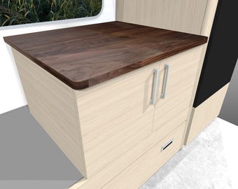 May include: A light wood cabinet with a dark brown wooden countertop. The cabinet has two doors with silver handles and a drawer. The cabinet is part of a larger structure, possibly a built-in unit.