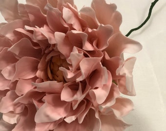 May include: A single, blush pink, artificial flower with a green stem. The flower is made of fabric and has a realistic appearance.