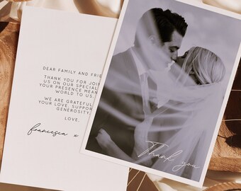 May include: A white card with a handwritten thank you message to family and friends. The card is on a wooden surface with a photo of a couple kissing in the background. The photo is in black and white and has a soft, dreamy filter applied.