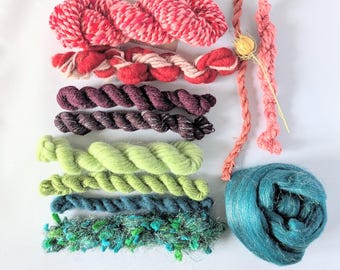 May include: A collection of colorful yarn skeins in various textures and shades. The yarns include red and white, purple, green, teal, and pink. Some yarns are twisted, while others are fluffy or fringed, suitable for crafting projects.